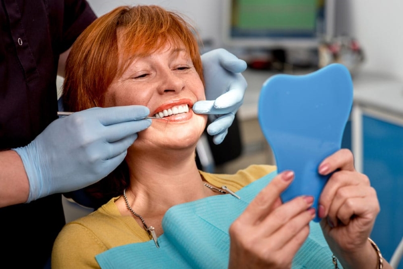 dental-patient-smiling-with-a-mirror-portland-oregon-advanced-dentistry